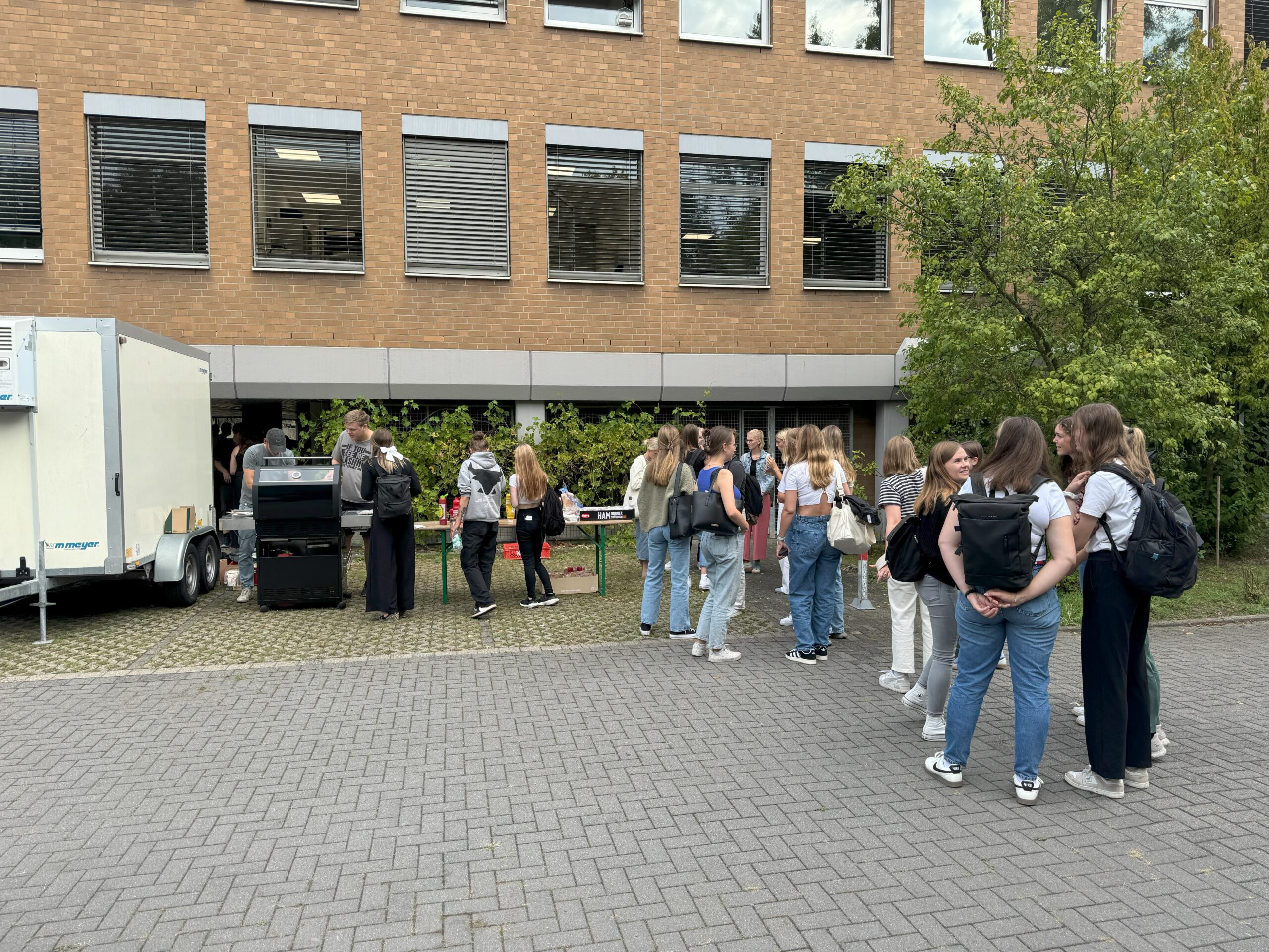 Gruppe von Studierenden vor dem Grill